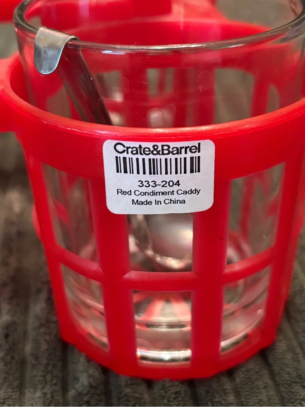 Crate & Barrel Red condiment caddy with four glass jars and metal spoons